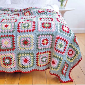 Peut inclure: Une couverture en crochet avec un motif de carrés de grand-mère dans des tons de bleu, vert, rose, rouge et jaune. La couverture est faite avec un fil doux et a un bord frangé.