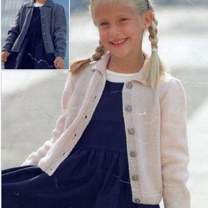 May include: A pale pink knitted cardigan with a collared neckline and button fastening. The cardigan is worn over a dark blue dress. The image also includes a smaller inset image of the same cardigan in a different colour.