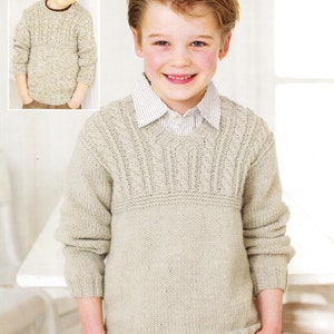 May include: A light beige knitted sweater with a cable knit pattern around the neckline. The sweater has a V-neck and long sleeves. The sweater is shown on a young boy wearing jeans.