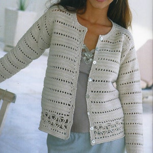 Può includere: Un cardigan beige lavorato a uncinetto con chiusura a bottoni e un delicato bordo in pizzo. Il cardigan è realizzato con un filato leggero e ha una vestibilità rilassata.