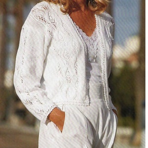 May include: A white crocheted cardigan with a delicate lace pattern. The cardigan has a V-neck and long sleeves.