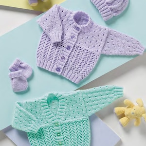 Pode incluir: Dois cardigans de malha para bebé, um em lavanda e outro em verde menta, com chapéus e luvas combinando. Os cardigans apresentam um delicado padrão de renda e fechos de botão.