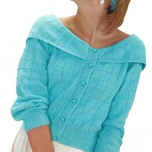 May include: A light blue knitted cardigan with a wide, folded collar and button closure. The cardigan has a textured pattern and is worn over a white skirt.