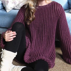 May include: A deep purple knitted jumper with a ribbed texture. The jumper has a round neckline and long sleeves.