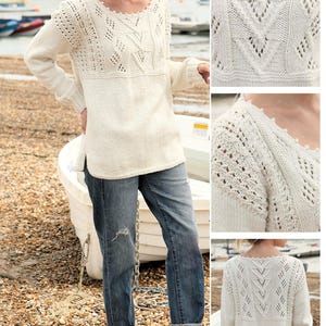 Peut inclure: Pull en tricot crème avec des motifs ajourés complexes et une encolure festonnée. Le pull présente un motif géométrique à l'avant et à l'arrière. Le modèle porte un jean bleu et des sandales. L'arrière-plan montre une plage et des bateaux.
