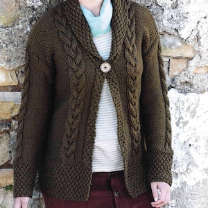 May include: A brown knitted cardigan with a cable knit pattern and a single button closure. The cardigan has a wide collar and long sleeves.