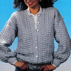 May include: A light blue knitted cardigan with a button-up front and a delicate openwork pattern. The cardigan has long sleeves and a relaxed fit.