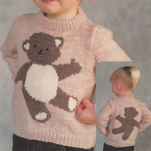 Puede incluir: Un suéter de punto rosa con un diseño de oso de peluche marrón en la parte delantera y un diseño de oso de peluche marrón en la parte posterior.