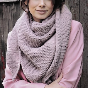 May include: A light mauve knitted scarf draped over a pink blazer. The scarf has a textured, chunky knit design. The text in the image says "lush muted shades, you are sure to find one that is perfect for your wardrobe."