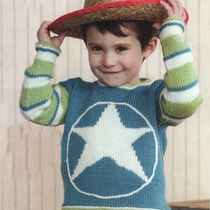 May include: A child's blue knit sweater with a large white star design, framed by a white circle. The sleeves feature green and white stripes. The child is wearing a straw cowboy hat with a red star.