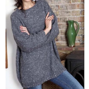 May include: A gray speckled knit sweater with long sleeves and a relaxed fit.