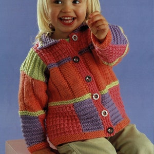 Peut inclure: Un cardigan tricoté coloré pour enfant, avec un motif patchwork dans des tons d'orange, de vert, de violet et de rose. Le cardigan a une fermeture boutonnée et un col.