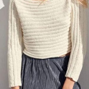 May include: A white knitted sweater with a wide neckline and long sleeves. The sweater is cropped and has a ribbed texture.