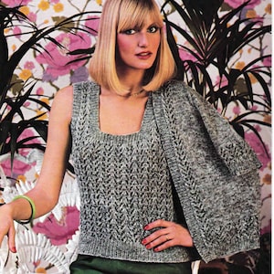 May include: A grey sleeveless knitted top with a matching cardigan. The top has a square neckline and a delicate lace pattern. The cardigan has a V-neckline and a similar lace pattern.