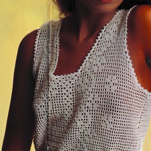 May include: A white crocheted top with a white headband. The top has a loose fit and a scalloped hem.