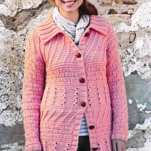 May include: A pink knitted cardigan with a button closure and a textured pattern. The cardigan has a collar and long sleeves.