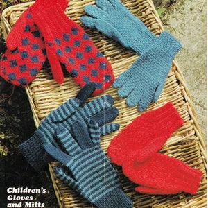 Può includere: Quattro paia di guanti e muffole di lana in rosso, blu e bianco. I guanti e le muffole sono esposti su un cesto di vimini.  Guanti e muffole per bambini.