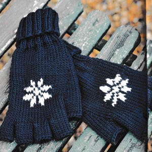 May include: A pair of fingerless gloves with a snowflake design. The gloves are dark blue with white snowflakes. The gloves are knitted and have a ribbed texture.