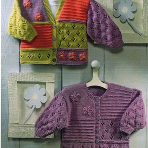 May include: Two knitted cardigans with floral embellishments. The top cardigan is multicolored with a patchwork design. The bottom cardigan is a solid purple.