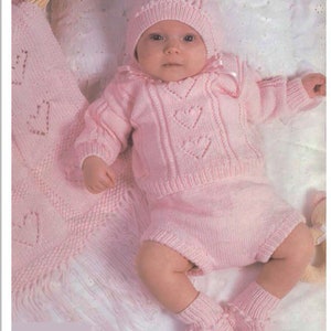 May include: A pink knitted baby outfit with a matching hat and booties. The outfit features a heart pattern and is made of soft yarn.