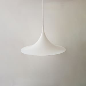 May include: A white pendant light with a wide, flat, saucer-shaped shade and a pointed, cone-shaped top.
