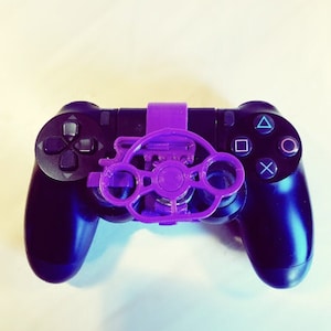 Op de afbeelding: Een paarse 3D-geprinte stuuraanpassing voor een zwarte PlayStation 4-controller.