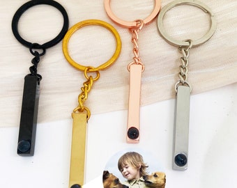 May include: Four keychains with different colored metal bars. Each bar has a small round photo insert. The photo insert shows a child and two dogs.