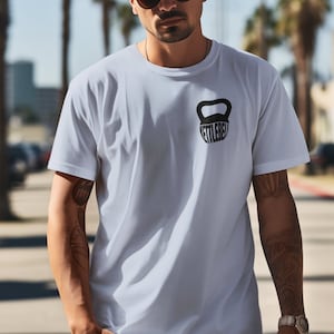 May include: A white t-shirt featuring a black kettlebell graphic with the word "Kettlebell" printed on it.