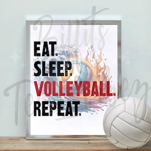 May include: A framed print with the words "EAT. SLEEP. VOLLEYBALL. REPEAT." in black and red. The artwork features a volleyball design with water and fire elements. A white volleyball sits on a wooden surface.