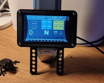 以下が含まれることがあります： 黒と青のデジタルディスプレイで、黒いフレームとスタンドが付いています。ディスプレイには「TROC」と「DRS」の文字と、数字と文字の列が表示されています。ディスプレイは、一連の穴のある黒いスタンドに取り付けられています。