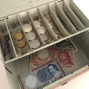 Vintage Dutch banknotes and coins in money box