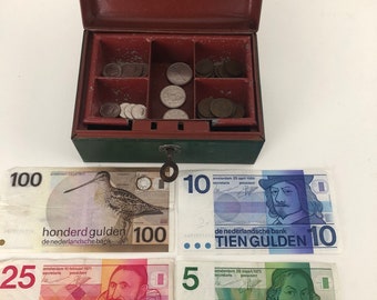 Vintage green money box with Dutch guilders in banknotes and coins