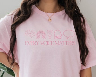 Puede incluir: Una camiseta rosa de gran tamaño con un gráfico de órganos humanos y el texto "Every Voice Matters".
