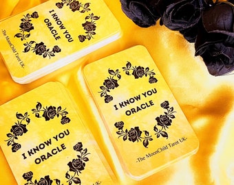 Könnte beinhalten: Drei Stapel Orakelkarten mit dem Text "I Know You Oracle" und einem schwarzen Rosenmuster. Die Karten liegen auf einer gelben Satin-Oberfläche.