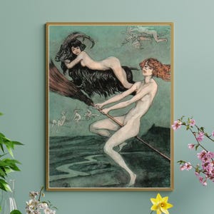 Puede incluir: Una impresión enmarcada con una ilustración vintage de dos figuras desnudas montando una escoba. Una figura tiene el pelo rojo y dirige la escoba, mientras que la otra monta una cabra negra. La obra de arte tiene un fondo verde azulado y un marco dorado.