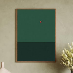 Puede incluir: Una impresión artística abstracta enmarcada con un fondo verde de dos tonos y un pequeño acento rojo. La parte superior es de un tono verde más claro, mientras que la sección inferior es de un verde más oscuro. La obra de arte está en un marco de madera.