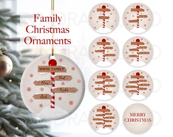 Puede incluir: Conjunto de ocho adornos navideños redondos con un poste de caramelo rojo y blanco con señales direccionales de madera. Un adorno tiene el texto "Smith Family" y nombres en las señales. Otro adorno tiene el texto "Feliz Navidad".