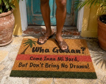 Pode incluir: Um capacho retangular com um gráfico de palmeira e o texto "Wha Gwaan? Come Inna Mi Yard, But Don't Bring No Drama!" O tapete tem listras marrons, vermelhas e verdes.