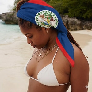 May include: A headscarf featuring the national flag of Belize, characterized by a blue field with red horizontal stripes at the top and bottom edges, and a central white circular emblem depicting two figures and a tree.