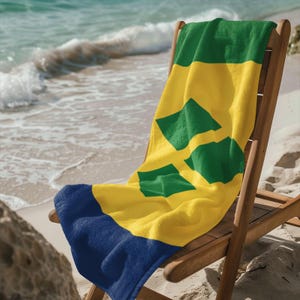 May include: A yellow, green, and blue beach towel with the flag of Saint Vincent and the Grenadines draped over a wooden beach chair.