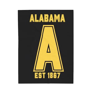 Könnte beinhalten: Schwarze Decke mit einem großen gelben Buchstaben "A" mit schwarzem Umriss, dem Wort "ALABAMA" darüber und "EST 1867" darunter. Das Design ist mittig auf der Decke platziert.