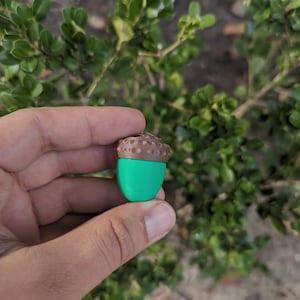May include: A green and brown acorn shaped object.