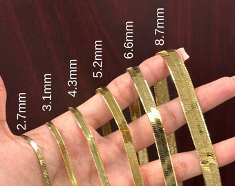 May include: A set of seven gold snake chains of varying widths, ranging from 2.7 mm to 8.7 mm. The chains are displayed on a hand, with the widths labeled in millimeters.