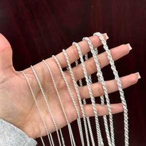 May include: A collection of silver rope chains of varying lengths and thicknesses.