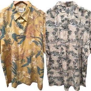 May include: Two short-sleeved button-down shirts. One is mustard yellow with a floral pattern in pink, teal, and white. The other is tan with a tropical landscape print featuring palm trees, mountains, and people.