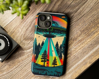 May include: A smartphone case featuring a colorful graphic illustration of a flying saucer hovering over a forest landscape. The design includes a vibrant sunset sky, a beam of light descending from the craft, pine trees, and a small lake silhouette.