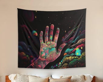Puede incluir: Un tapiz de pared rectangular que presenta una mano abierta central cubierta con patrones intrincados y multicolores sobre un fondo cósmico oscuro lleno de nebulosas arremolinadas, orbes brillantes y formas abstractas fluidas.
