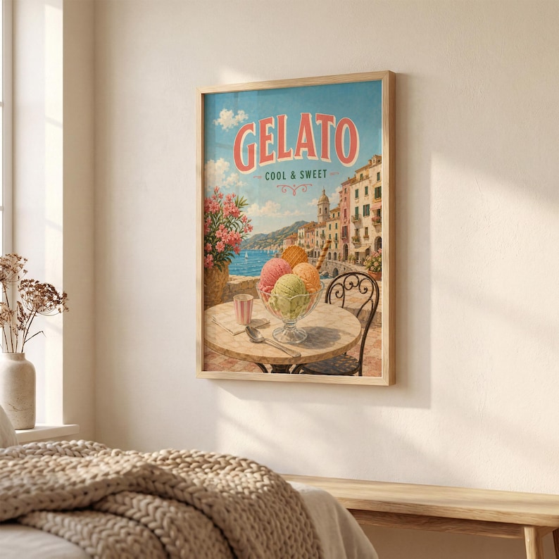 May include: A framed print featuring a vintage gelato advertisement. The artwork displays a seaside scene with colorful buildings, a table with gelato, and the text "GELATO COOL & SWEET" in a retro font. The frame is a light wood color.