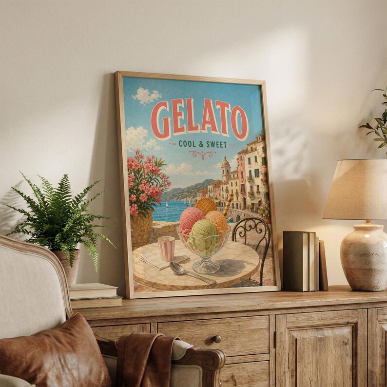 May include: Framed vintage-style poster with the word "Gelato" in red script. The poster depicts a seaside scene with gelato in a glass bowl on a table. The poster has a light blue sky and a wooden frame.