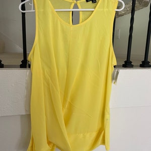 May include: A bright yellow sleeveless top with a keyhole back detail. The top is made of a lightweight fabric and has a relaxed fit.